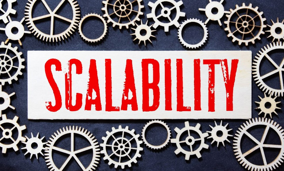 The concept of scalability in network design visualized as the word scalability surrounded by machine cogs of various sizes.