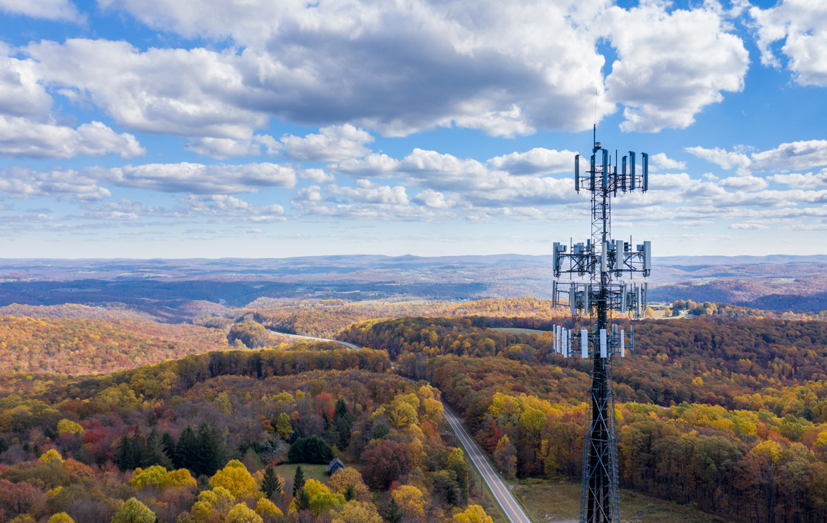 A wireless network communication tower in a rural area that could benefit from 6GHz spectrum broadband.